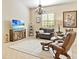 Cozy living room with leather seating, decorative lighting, and a large flat-screen television at 305 Rio Terra, Venice, FL 34285