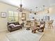 Bright living room featuring leather seating, chandelier, and an open layout to the kitchen at 305 Rio Terra, Venice, FL 34285