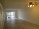 Spacious living room features tile floors, a ceiling fan, and sliding glass doors to a screened porch at 509 Parkdale Mews # 509, Venice, FL 34285