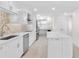 Modern white kitchen with stainless steel appliances and marble countertops at 5790 Midnight Pass Rd # 602, Sarasota, FL 34242