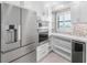 Modern kitchen features white cabinets, quartz counters, and wine cooler at 5790 Midnight Pass Rd # 602, Sarasota, FL 34242