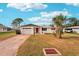 White single story home with red door, attached garage, and landscaped lawn at 872 Mohawk Rd, Venice, FL 34293
