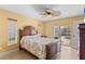 Bedroom with a wooden bed frame, ceiling fan, and access to the pool area at 9325 Crugar Ter, Englewood, FL 34224