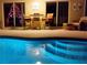 Lighted pool at night with patio seating at 9325 Crugar Ter, Englewood, FL 34224