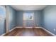 Blue bedroom with wood flooring and window with curtains at 1040 Hope St, Venice, FL 34285