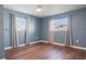 Blue bedroom with wood flooring and window with curtains at 1040 Hope St, Venice, FL 34285