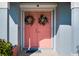 Double coral pink front doors adorned with matching wreaths at 108 Hourglass Dr, Venice, FL 34293