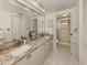 Double vanity bathroom with granite countertops and a large mirror at 1100 Capri Isles Blvd # 212, Venice, FL 34292