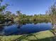 Serene pond view, reflecting the surrounding trees and sky at 1100 Capri Isles Blvd # 212, Venice, FL 34292