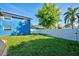 Large backyard with grassy area, white fence, and mature tree at 113 Colonia W Ln, Nokomis, FL 34275