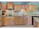 Modern kitchen featuring granite countertops and light wood cabinets at 113 Colonia W Ln, Nokomis, FL 34275