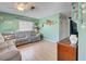 Living room with large sectional sofa and light colored wood floors at 113 Colonia W Ln, Nokomis, FL 34275