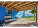 Covered patio with blue walls, a bar area, and a view of the yard at 113 Colonia W Ln, Nokomis, FL 34275