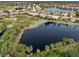 Wide aerial view of upscale community with lake and conservation area at 114 Medici Ter, North Venice, FL 34275