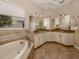Spa-like bathroom with corner vanity and soaking tub at 114 Medici Ter, North Venice, FL 34275