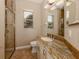 Bathroom with granite countertop, tiled shower, and updated fixtures at 114 Medici Ter, North Venice, FL 34275