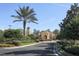 Landscaped entry to community center with palm trees and clock tower at 114 Medici Ter, North Venice, FL 34275