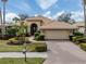 Tan house with tile roof, landscaping, and driveway at 114 Medici Ter, North Venice, FL 34275