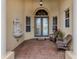Front entry with double doors, fountain, and wicker chairs at 114 Medici Ter, North Venice, FL 34275