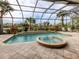 Screened pool and spa with lush landscaping and outdoor seating at 114 Medici Ter, North Venice, FL 34275