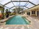 Screened pool and spa with lush landscaping and outdoor seating at 114 Medici Ter, North Venice, FL 34275