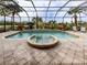Screened pool and spa with lush landscaping and outdoor seating at 114 Medici Ter, North Venice, FL 34275
