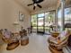 Relaxing screened porch with wicker furniture and ceiling fan at 11584 Dancing River Dr, Venice, FL 34292