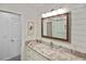 Bathroom with a marble-topped vanity and large mirror at 1200 Tarpon Center Dr # 108, Venice, FL 34285