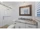 Bathroom boasting marble countertops, a glass shower, and a modern, framed mirror at 1200 Tarpon Center Dr # 108, Venice, FL 34285