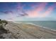 Expansive beach with a long shoreline and tire tracks in the sand, under a mesmerizing twilight sky at 1200 Tarpon Center Dr # 108, Venice, FL 34285