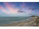 Scenic beach view with pink and blue sky reflecting over the water and shoreline at 1200 Tarpon Center Dr # 108, Venice, FL 34285