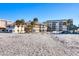 Beachfront view of multiple buildings with palm trees and beach access at 1200 Tarpon Center Dr # 108, Venice, FL 34285