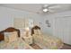 Guest bedroom with twin beds, wicker headboards, and coastal decor at 1200 Tarpon Center Dr # 108, Venice, FL 34285