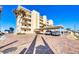 Beautiful building exterior with balconies, palm trees, and a covered parking area at 1200 Tarpon Center Dr # 108, Venice, FL 34285