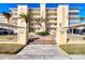 Beautiful building exterior with balconies, palm trees, and a covered parking area at 1200 Tarpon Center Dr # 108, Venice, FL 34285