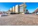 View of a four story building with balconies and palm trees and adjacent parking area at 1200 Tarpon Center Dr # 108, Venice, FL 34285