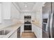 Bright kitchen featuring stainless steel appliances, white cabinets, and hardwood floors at 1200 Tarpon Center Dr # 108, Venice, FL 34285
