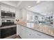 Open kitchen with stainless steel appliances and views into the dining and living areas at 1200 Tarpon Center Dr # 108, Venice, FL 34285