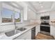 Bright kitchen with stainless steel appliances, granite countertops, and white cabinetry at 1200 Tarpon Center Dr # 108, Venice, FL 34285