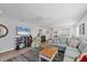 Spacious living room with modern decor, including a ceiling fan and views to the dining and kitchen area at 1200 Tarpon Center Dr # 108, Venice, FL 34285