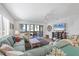 Bright living room featuring comfortable seating, a ceiling fan, and access to the screened porch at 1200 Tarpon Center Dr # 108, Venice, FL 34285