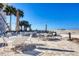 Outdoor patio dining area with cafe tables and chairs overlooking the beautiful beach at 1200 Tarpon Center Dr # 108, Venice, FL 34285
