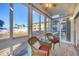 Bright sunroom with tiled floor, wicker furniture, and views of the beach at 1200 Tarpon Center Dr # 108, Venice, FL 34285