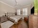 Bright bedroom with wood floors, a ceiling fan, and plantation shutters at 121 Preserve Pl # A, Nokomis, FL 34275