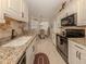 Modern kitchen with granite countertops, white cabinets, and black appliances at 121 Preserve Pl # A, Nokomis, FL 34275
