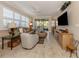 Spacious living room with light tile floors, comfortable seating, and a large TV at 121 Preserve Pl # A, Nokomis, FL 34275