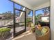 Screened porch with wicker chairs, providing outdoor space at 121 Preserve Pl # A, Nokomis, FL 34275