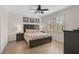 Comfortable bedroom with a queen-sized bed, wood-look floors, and a ceiling fan at 125 Soliera St, Nokomis, FL 34275