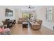 Spacious living room with light beige leather sofas, wood flooring, and a view into the kitchen at 125 Soliera St, Nokomis, FL 34275