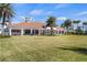 Clubhouse exterior with a covered patio, lawn and palm trees, perfect for community events at 12837 Oriago St, Venice, FL 34293